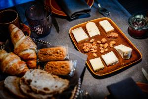 a table topped with a tray of cheese and bread at Porta Superia Boutique B&B in Mechelen
