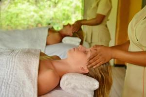 a woman laying on a bed getting a massage at Lokuthula Lodge in Victoria Falls