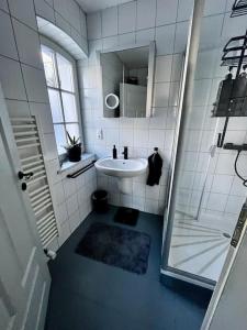 a white bathroom with a sink and a mirror at Bahnwärterhäuschen - 1873 in Feucht