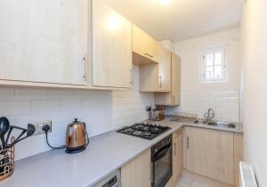 a kitchen with white cabinets and a stove top oven at The Well Court Residence in Edinburgh