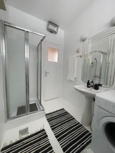 baño blanco con ducha y lavamanos en Apartment Mirochka, en Belgrado