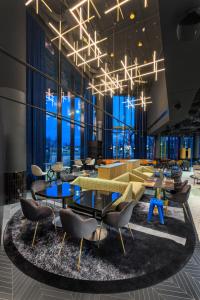 um átrio com mesas, cadeiras e janelas em TRIBE Budapest Stadium em Budapeste