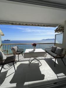 uma varanda com mesa e cadeiras e vista para o oceano em Sea View Bellamare next Palais Festival em Cannes
