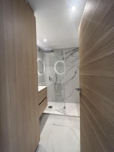 a bathroom with a shower and a glass door at Sea View Bellamare next Palais Festival in Cannes