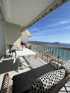 uma varanda com uma mesa e cadeiras e o oceano em Sea View Bellamare next Palais Festival em Cannes