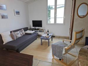 ein Wohnzimmer mit einem Sofa und einem TV in der Unterkunft Maison vue mer à 200 M de la plage Corn Ar Gazel in Saint-Pabu