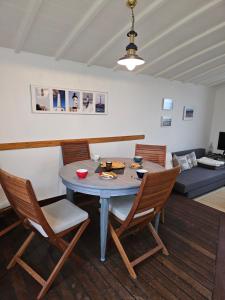 einen Esstisch und Stühle im Wohnzimmer in der Unterkunft Maison vue mer à 200 M de la plage Corn Ar Gazel in Saint-Pabu