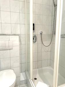 ein Bad mit einer Dusche und einem WC in der Unterkunft City Hotel Valois in Wilhelmshaven