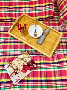 a wooden tray with a spoon and a magazine on a bed at Flower house 10 in Sofia