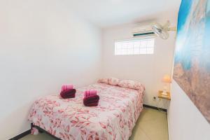 - une chambre avec un lit et des serviettes pourpres dans l'établissement Kas Kanoa Curacao - Flamingo, à Willemstad