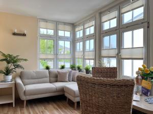 a living room with a couch and some windows at Villa Trautes Heim in Ahlbeck