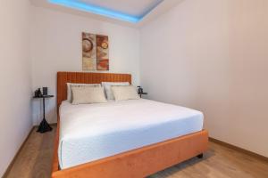 a bedroom with a bed with white sheets and a blue ceiling at Efrosini Apartments in Heraklio