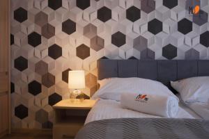 Schlafzimmer mit einem Bett mit sechseckiger Wand in der Unterkunft Perłowa Przystań Premium by MS Pro Apartamenty in Kołobrzeg