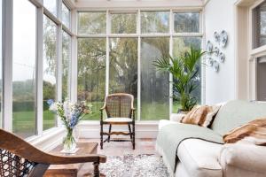 a living room with large windows and a couch at Sparkenhoe House in Nuneaton