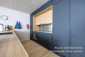 Luksushuvila Villa Helmi في يامسا: مطبخ مع دواليب سوداء ومكتب