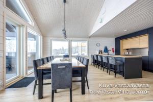 Luksushuvila Villa Helmi في يامسا: مطبخ وغرفة طعام مع طاولة وكراسي