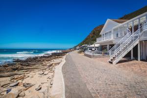 a house on the beach next to the ocean at Beachfront property, Victoria Bay, Garden route in Victoria Bay