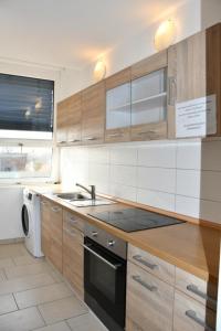 a kitchen with wooden cabinets and a sink and a dishwasher at GASTEM UG in Berlin