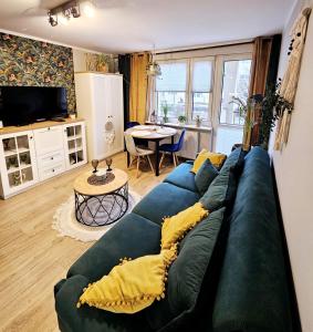 a living room with a blue couch with yellow pillows at Apartament Boho in Inowrocław