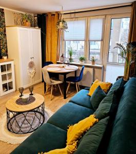 ein Wohnzimmer mit einem blauen Sofa und einem Tisch in der Unterkunft Apartament Boho in Inowrocław