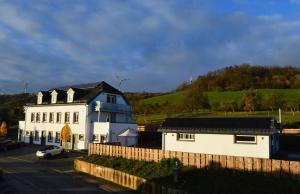 una casa blanca con una valla delante en Feriendomizil im Saarschleifenland - Ferienhaus Gätschenberger en Mettlach