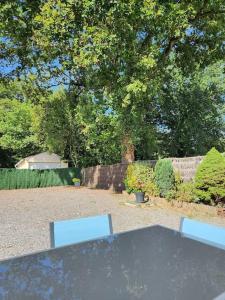 a picnic table and two benches in a yard at Maison cosy et décorée avec goût à la campagne in Sévérac