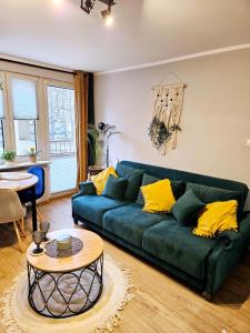 a living room with a green couch and a table at Apartament Boho in Inowrocław