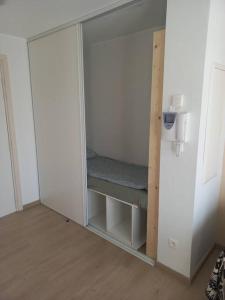 a white cabinet with a bench in a room at Appartement le peuplier proche de la plage. in Bray-Dunes