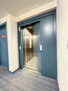 a blue door in a building with a hallway at Appartement le peuplier proche de la plage. in Bray-Dunes