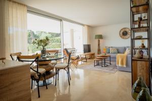 - un salon avec une table, des chaises et un canapé dans l'établissement Apartment Botanic View, à Benahavís