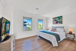 a white bedroom with a bed and two windows at Tranquil Escape by Ready Set Stay in Dromana