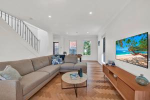 a living room with a couch and a tv on a wall at Tranquil Escape by Ready Set Stay in Dromana