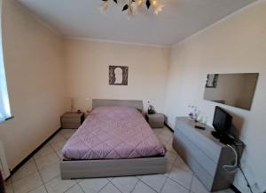 - une chambre avec un lit rose et une télévision dans l'établissement al 4e, à Montopoli in Val dʼArno