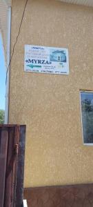 un panneau sur le côté d'un bâtiment dans l'établissement Myrza, à Kasymbek