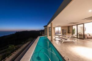 a villa with a swimming pool at night at Super Beachfront views- Executive Villa - 5 bedrooms in Knysna