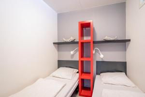 een rode ladder in een kamer met 2 bedden bij Appartementencomplex Juliana 46 in De Koog