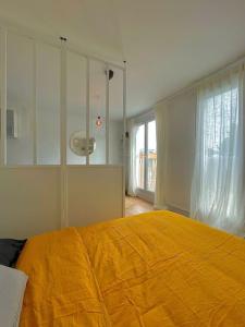 - une chambre avec un grand lit et une couverture jaune dans l'établissement Superbe Studio avec parking gratuit sur place, à Paray-Vieille-Poste