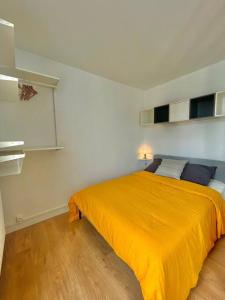 una camera da letto con un letto con una coperta arancione di Superbe Studio avec parking gratuit sur place a Paray-Vieille-Poste