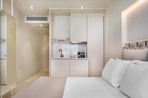 a small room with a bed and a sink at Cocoοns Suites & Villas Fourka in Fourka