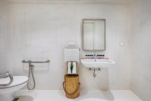 a white bathroom with a sink and a toilet at Cocoοns Suites & Villas Fourka in Fourka