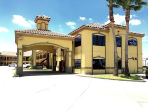 a building with a palm tree in front of it at Boca Chica Inn and Suites in Brownsville