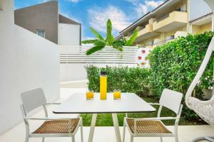 a white table and chairs on a patio with orange juice at Cocoοns Suites & Villas Fourka in Fourka