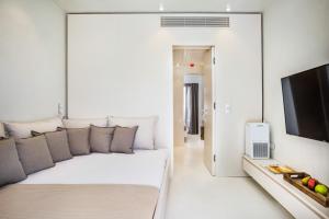 a living room with a couch and a flat screen tv at Cocoοns Suites & Villas Fourka in Fourka