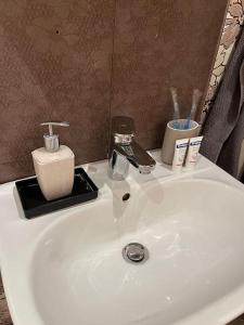 a white sink with toothbrushes and other items on it at Apartment with Sea View in Varna City