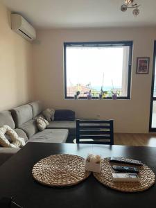 a living room with a table and a couch at Apartment with Sea View in Varna City