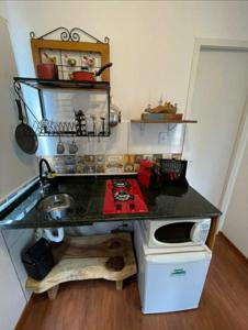 a small kitchen with a counter with a stove at Pousada Recanto dos Bentos in Itapeva