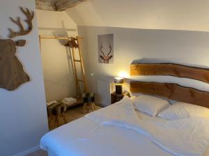 1 dormitorio con cama y cabeza de ciervo en la pared en Hôtel Restaurant Domaine De Basil en Orbey