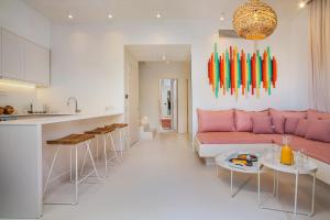 una cucina e un soggiorno con divano rosa di Cocoοns Luxury Suites & Villas a Fourka