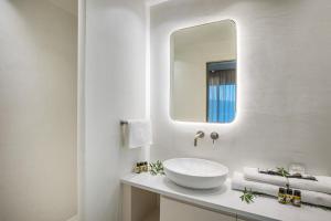 a white bathroom with a sink and a mirror at Cocoοns Suites & Villas Fourka in Fourka