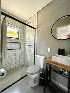 a bathroom with a toilet and a sink and a mirror at Pousada Recanto dos Bentos in Itapeva